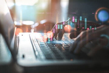 Close-up of hands typing on a laptop with futuristic analytics and business graphics overlay, depicting high-tech finance or market analysis..