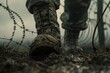 A soldiers muddy boots pacing near barbed wire, depicted in 3D under grim, moody lighting