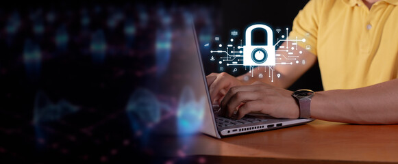 cybersecurity concept: businessman in yellow shirt uses laptop. padlock hologram