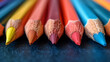Close-up of colorful sharpened pencils on a blue background, with selective focus.