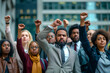 Diverse group of professional young business people standing together with raised arms in a fist at office