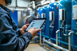 Modern factory process with team of service engineer in a water filtration control room and using a tablet computer to check process of raw water filtration for mineral water bottling production line