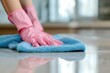 Person cleaning with pink gloves and blue cloth