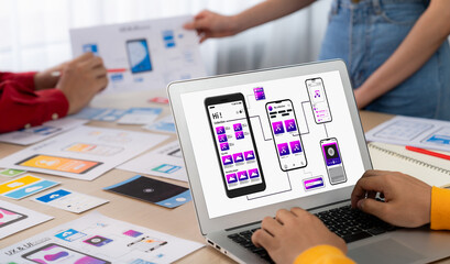 Panorama banner of startup UX developer or company employee design user interface or UI prototype for mobile application or website software with software display on laptop monitor in office. Synergic