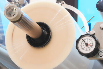Poster - Automatic polyethylene air-bubble packaging roll tape film machine with lighting effect in blue background in full screen