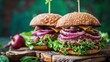 Two juicy beef burgers with cheddar cheese, mushrooms, lettuce and onions on a wooden board on a dark background.