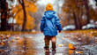 Little boy walking in the rain in blue jacket and brown pants.