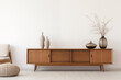 Midcentury modern retro wooden sideboard with two vases and a decorative plant in front of a white wall
