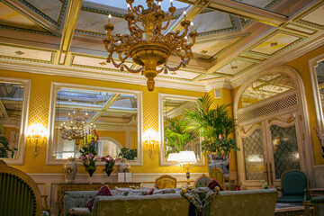 Opulent Vintage Drawing Room -  The luxurious interior of a vintage drawing room illuminated by the warm glow of a grand chandelier, with lavish decorations reflecting in the ornate mirrors.