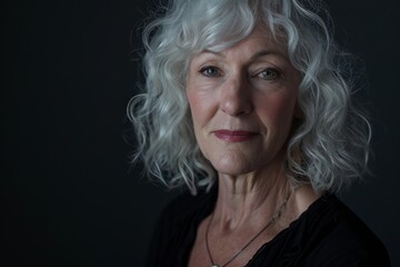 Wall Mural - Portrait of a beautiful senior woman with grey hair on a dark background