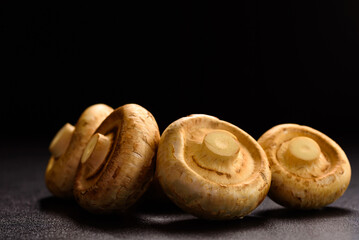 Wall Mural - Fresh organic button mushroom placed on black background. Local ingredient for healthy vegetarian meal