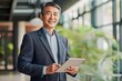 © A Denny Syahputra - Asian man holding tablet phone in office