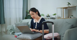 Fototapeta Mapy - Portrait of Asian teenager woman sitting on sofa using laptop for prepare booking hotel and airplane ticket for travel. backpacker travel concept.