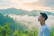 © A Denny Syahputra - Asian man enjoying the fresh morning air on the mountain, calming refreshing
