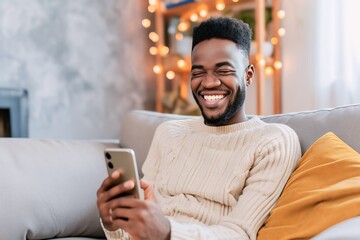 Wall Mural - African man playing with smartphone while laughing