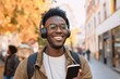 African man is listening to music on smartphone with headphones outdoors