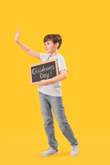 Sticker - Little boy holding chalkboard with text CHILDREN'S DAY on yellow background