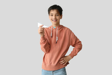 Poster - Little boy with paper plane on light background. Children's Day celebration