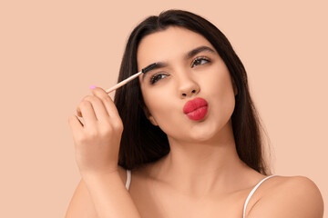 Sticker - Beautiful young woman with makeup brush blowing kiss on beige background