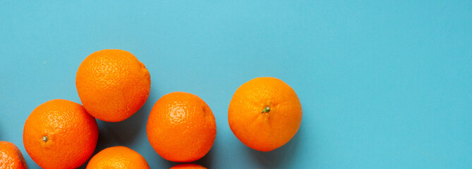 Line of fresh oranges top view banner. Vibrant photo of citrus fruits flat lay on blue background. Vitamin C