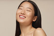 © AnnaStills - Closeup studio portrait of happy young Asian woman with long straight hair smiling with eyes closed