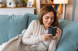 © Graphicroyalty - Young happy relaxed woman enjoying quiet moments at home with cup of tea or coffee, smiling female holding mug with hot drink resting on sofa in living room and dreaming, relaxing of everything