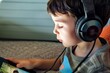 © studioworkstock - boy with headphones listening to a story on a digital tablet