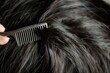 closeup of a comb lifting a section of dark hair