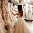 Girl wearing the bridal dress looking for y a wedding dress in the luxury salon