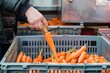© studioworkstock - person in a soup kitchen adding carrots to a donation crate