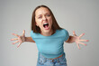 Portrait of angry crazy young woman on gray background