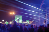 Fototapeta Uliczki - Night open air concert, light rays against Chain Bridge
