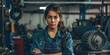 The concept of small business, feminism and women's equality. A young woman in working clothes posing in front of a car workshop