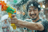 Fototapeta Panele - Happy traveler asian man wearing summer shirt holding colorful squirt water gun over blur city, Water festival holiday concept