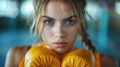 Sweaty female boxer with orange gloves in a gym. Intense boxing training concept.
