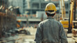 Back of a worker walking toward a construction site 