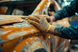 © Arlessa - Car body repair and patching, Hand applying the putty. A male technician using sand paper to smooth an damaged panel
