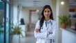 Indian woman doctor standing a hospital with crossed arms and looking at camera