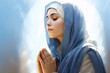 a woman with a blue head scarf and a blue scarf praying