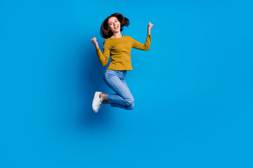 Wall Mural - full length photo of funky lucky woman wear shirt jumping high rising fists empty space isolated blu