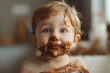 Baby with face covered in chocolate. Portrait of adorable small baby girl eating chocolate. Background with copy space.