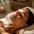 Young woman in spa salon lying on massage table and enjoying aroma therapy.