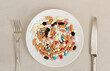 Plate of pills fork and knife next to it. Concept of excessive consumption of drugs that replace healthy diet.