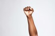 Fist of Determination: Symbol of Strength and Solidarity. An African woman's fist raised in a powerful gesture against a soft gray backdrop.