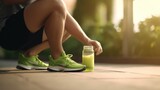 Fototapeta Konie - Fitness man tying running shoes and green smoothie breakfast.