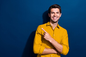 Wall Mural - Photo portrait of nice young male point empty space promo dressed stylish yellow garment isolated on dark blue color background