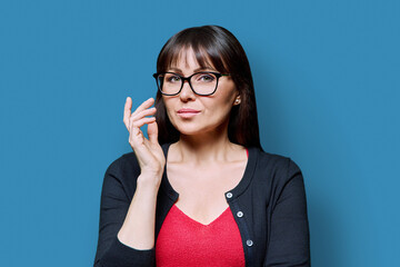 Wall Mural - Headshot portrait of serious business mature woman with on blue background