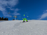 Fototapeta  - Happy kid in dynamic ski slope moment at alpine mountain resort