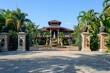 luxurious tropical mansion with a gated entry and fountain