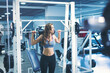 © Aleksandar - Young woman at the gym lifting weights
